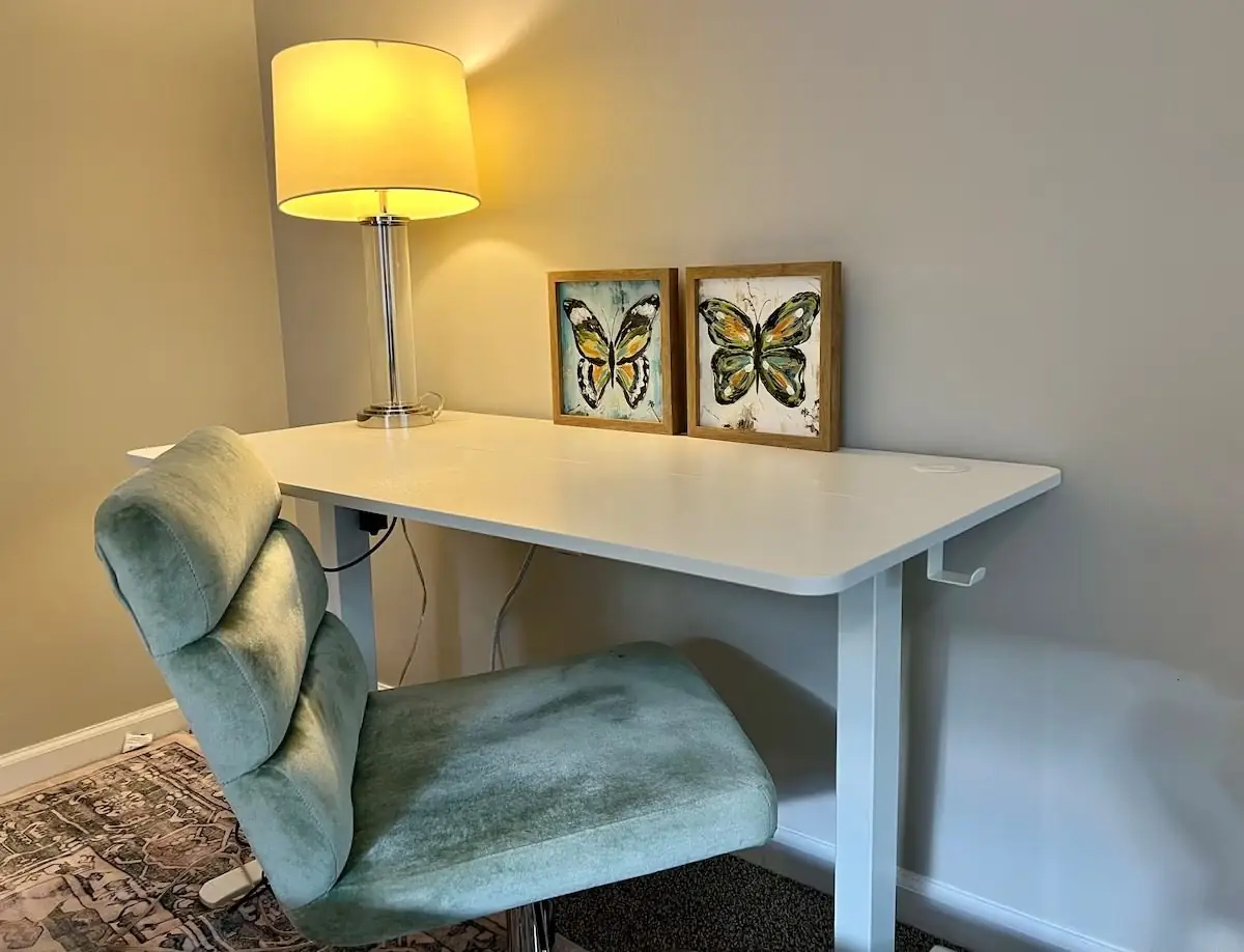 Work desk and chair wiped down and arranged in a short-term rental guest room in Carrollton, GA