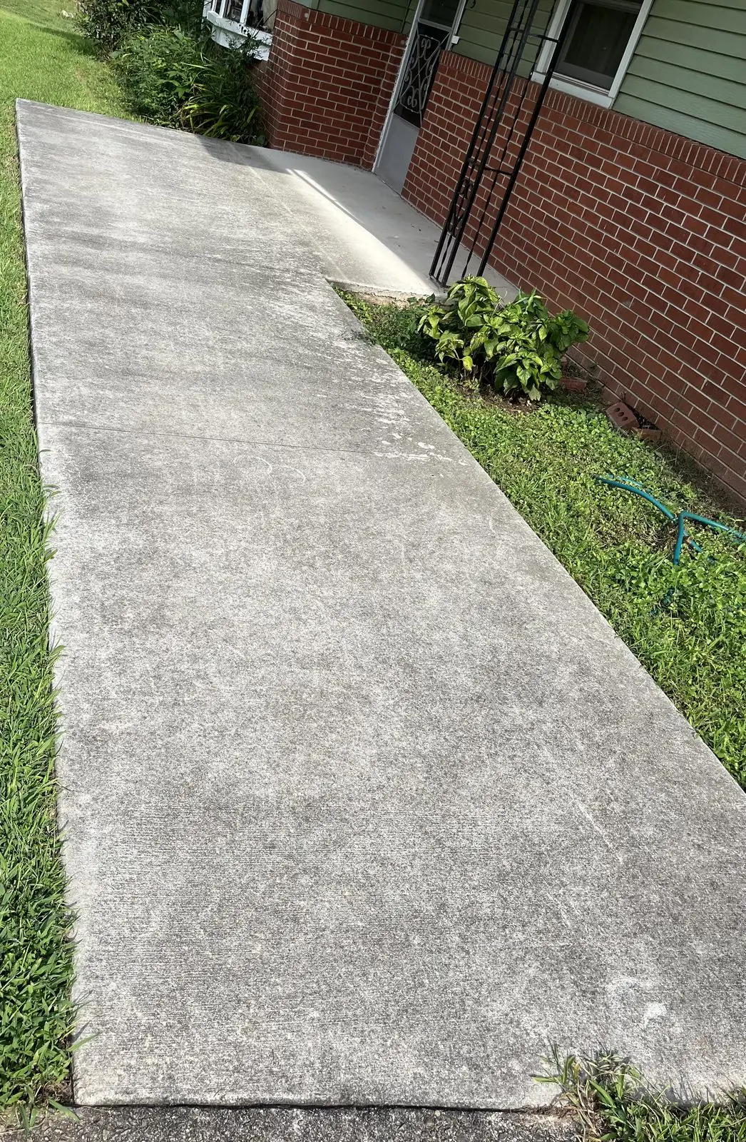 Stained concrete walkway before pressure washing in Temple, GA