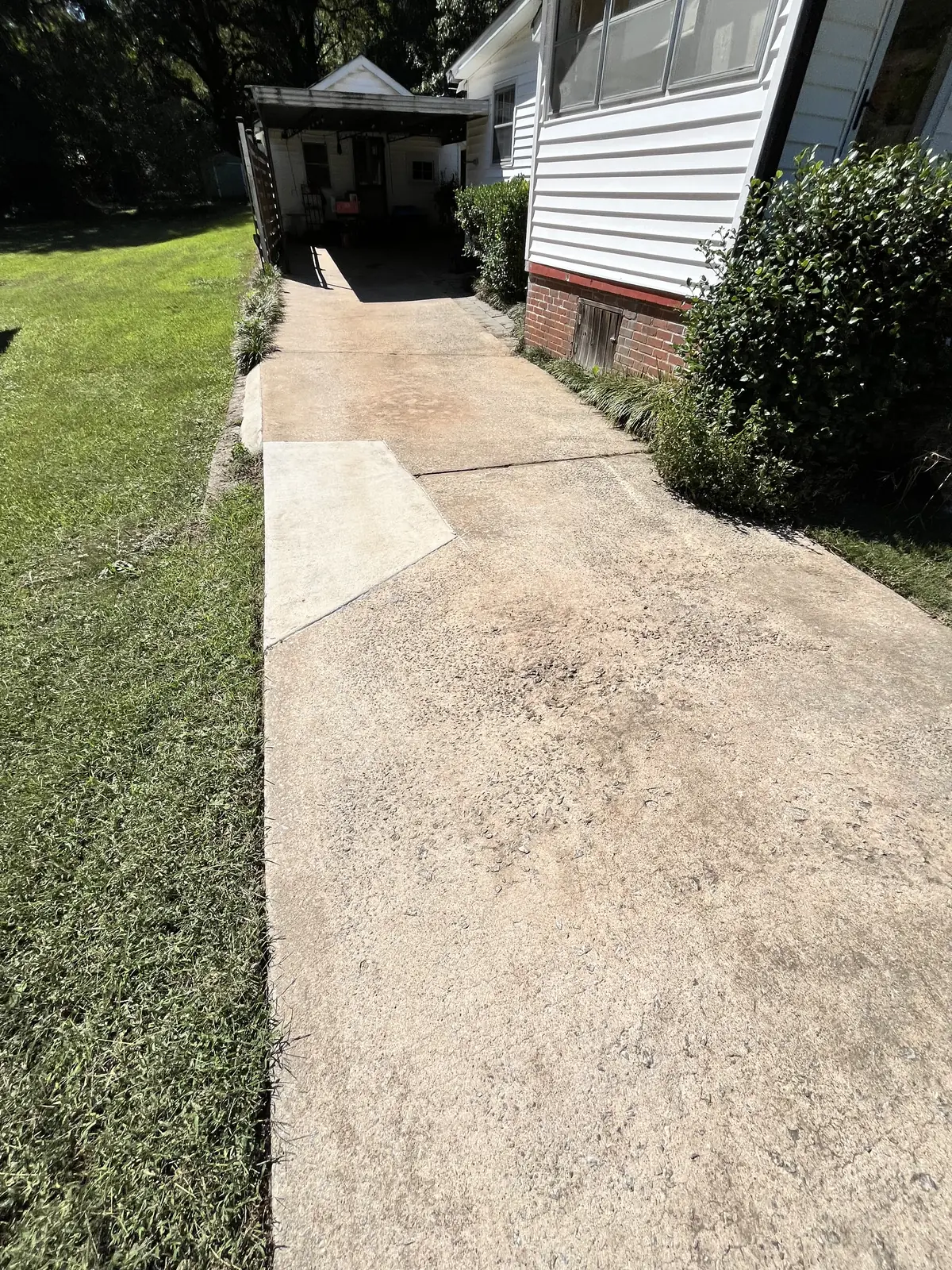 Same driveway back to bare concrete after pressure washing in Carrollton, GA