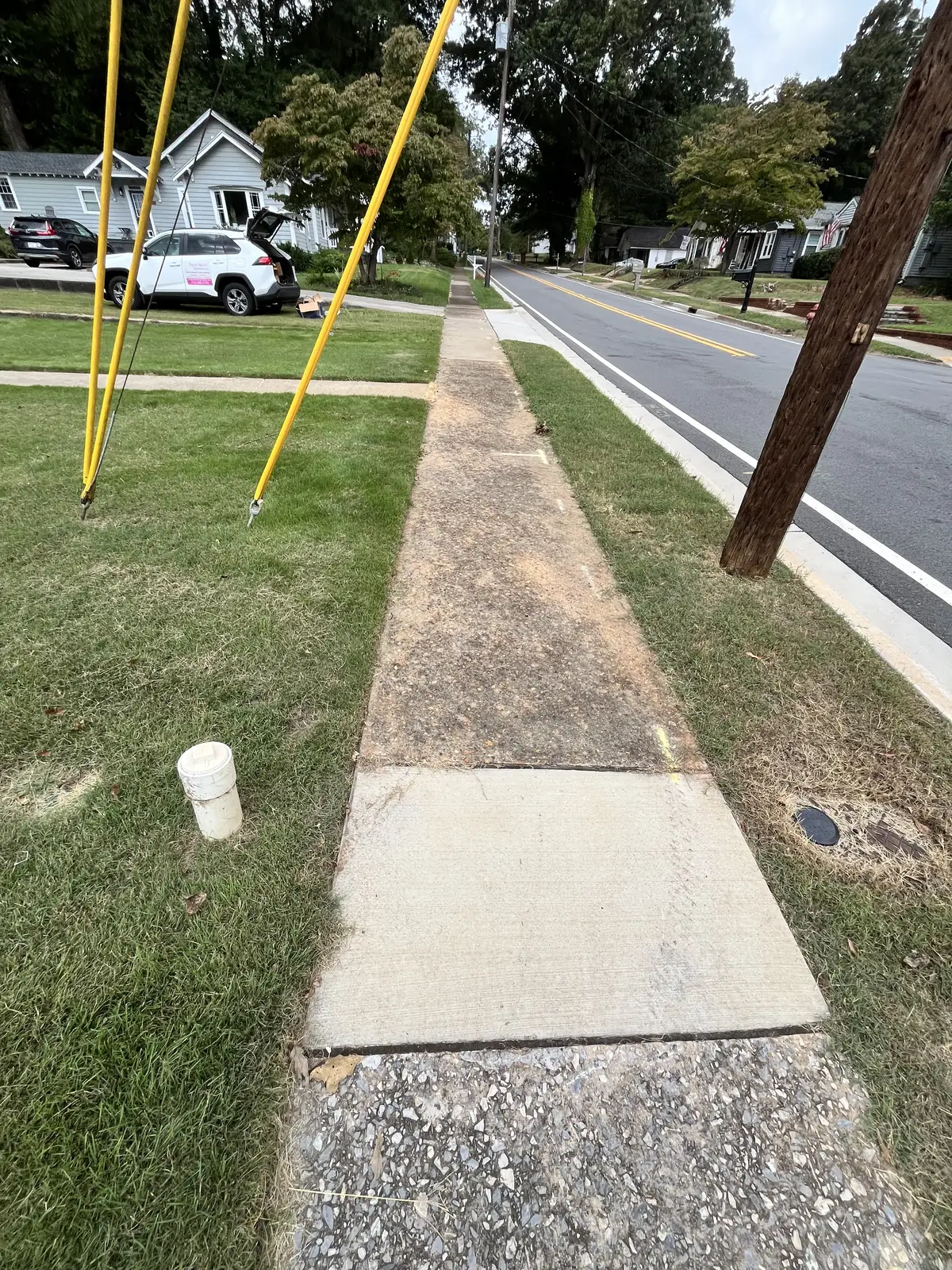 Street-side concrete sidewalk stained with dirt and mildew before pressure washing in Carrollton, GA