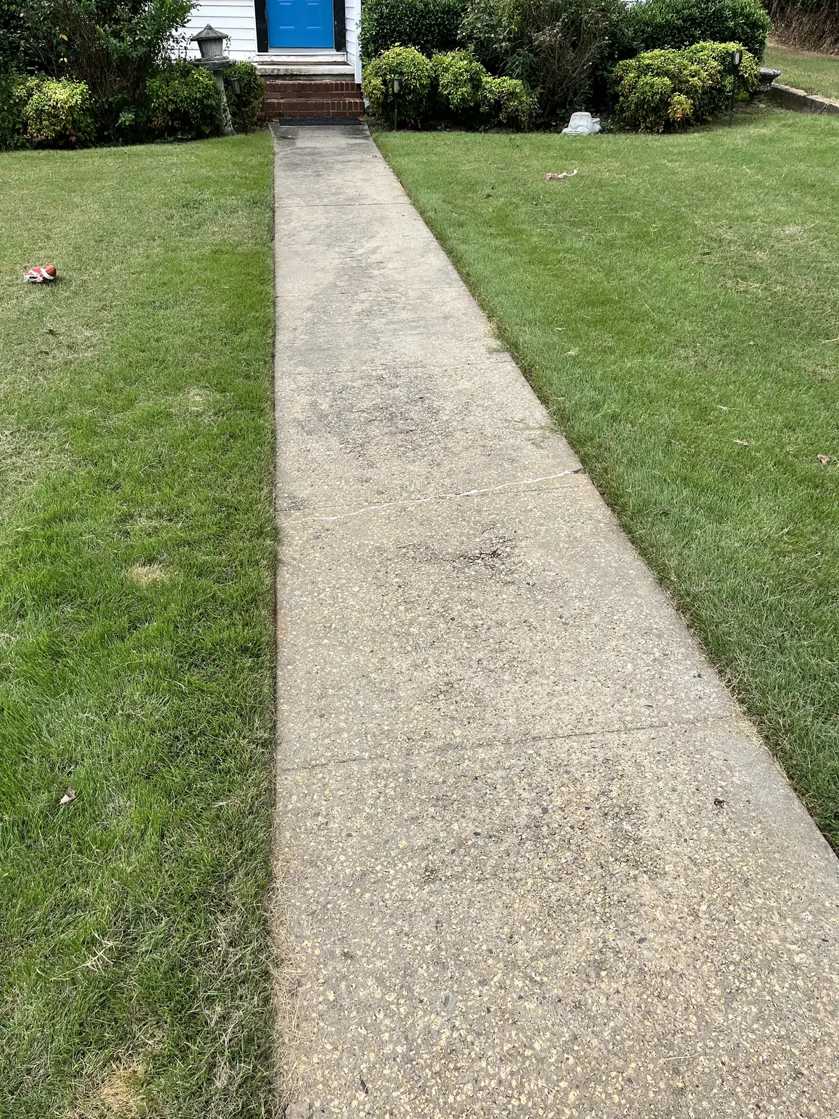 Front walkway to a house darkened with grime before pressure washing in Carrollton, GA