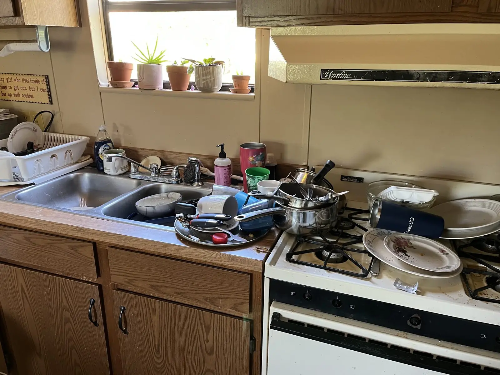 Kitchen sink and counter piled with dishes before cleaning in Carrollton, GA