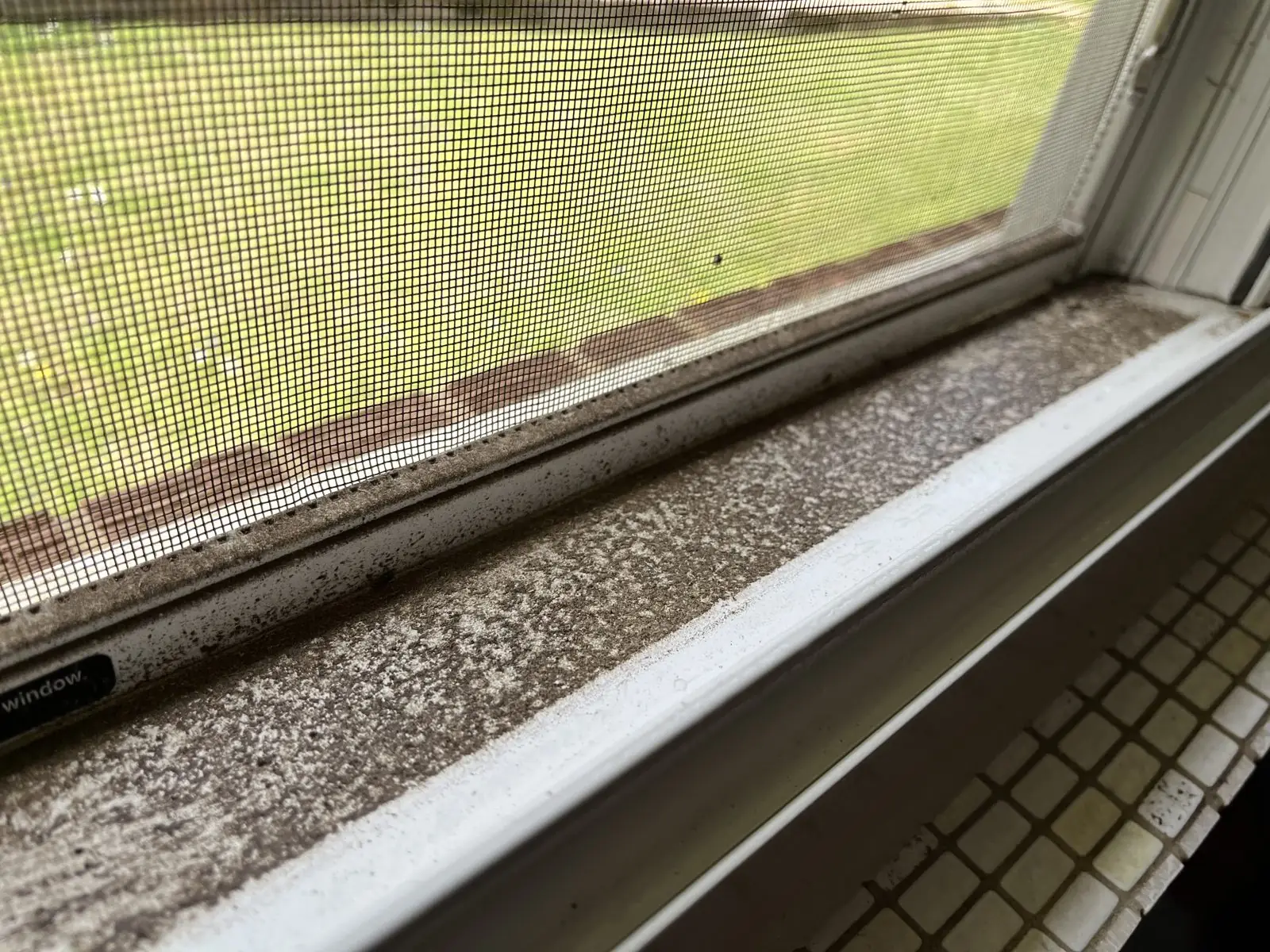 Window sill and track packed with dust and grit before cleaning in Carrollton, GA