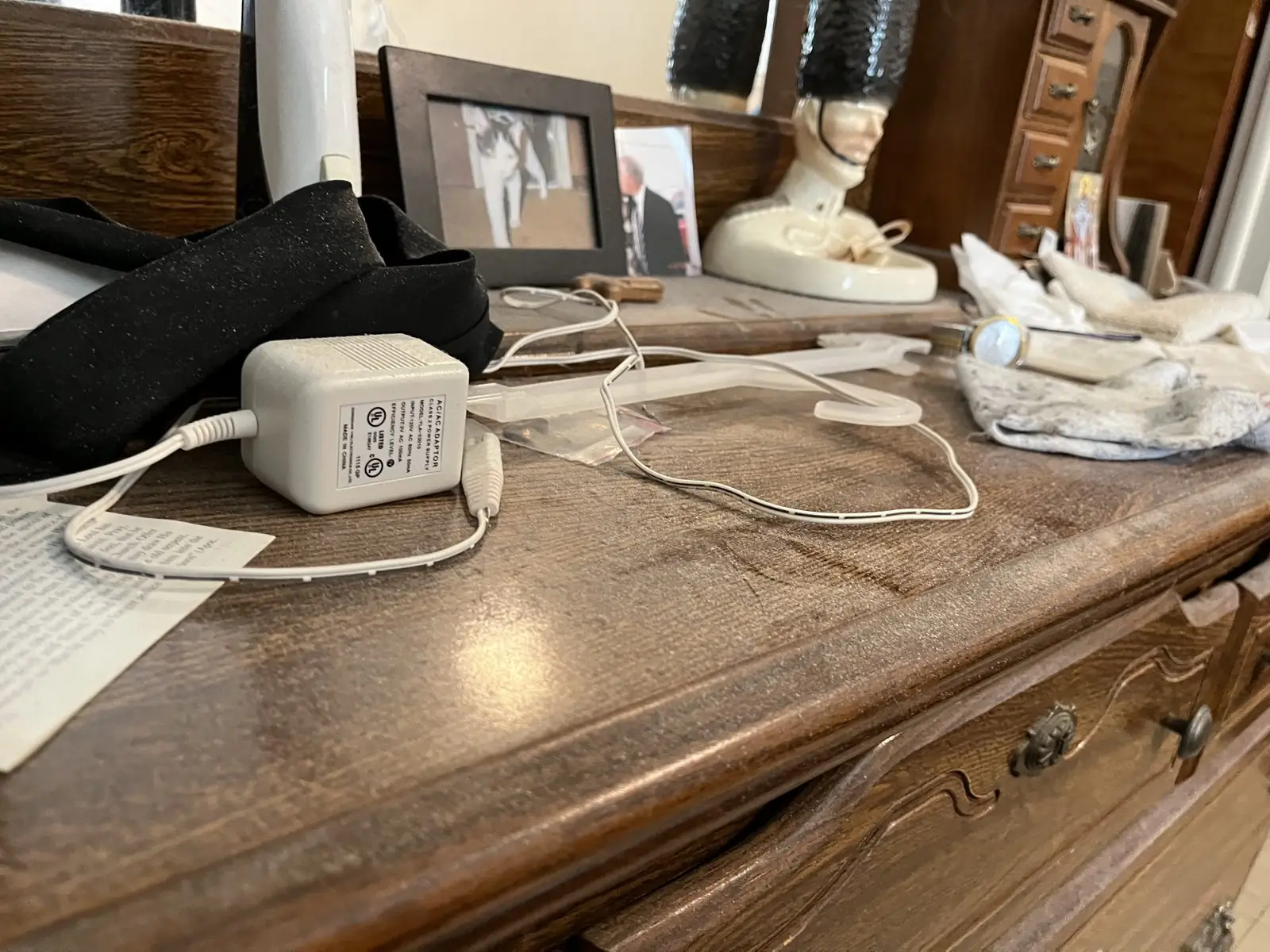 Dresser top covered in dust, cords and clutter before cleaning in Carrollton, GA